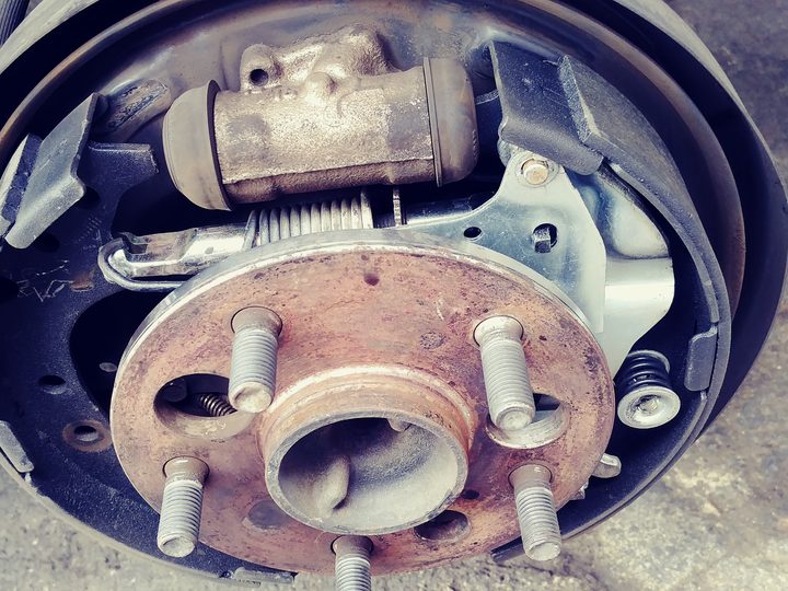 A close-up of a wheel hub with the brake shoes, the spring and the wheel cylinder behind it.